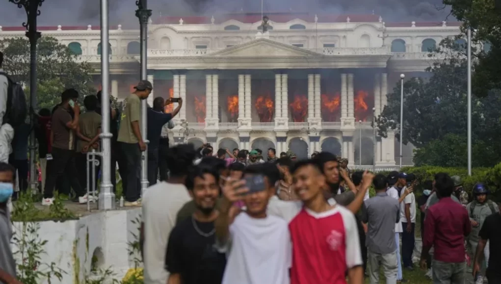 Des manifestants se prennent en photo et c&eacute;l&egrave;brent devant le Singha Durbar, apr&egrave;s qu&rsquo;il a &eacute;t&eacute; incendi&eacute; lors d&rsquo;une manifestation &agrave; Katmandou, au N&eacute;pal, le 9 septembre 2025 | Photo: AP