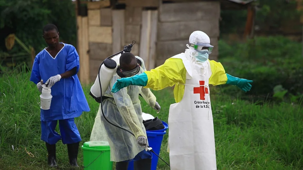 Le 9 septembre 2018, un agent de santé asperge son collègue de désinfectant après avoir travaillé dans un centre de traitement d'Ebola à Beni, dans l'est du Congo | Photo: AP