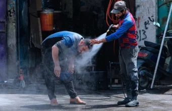 Vagues de Chaleur: Un Milliard de Personnes de Plus Exposées Un homme se rafraîchit sous une chaleur de 51 °C à Bassora, en Irak, le 1er juillet 2021 | Photo: AP